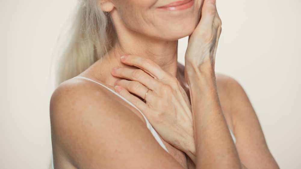 Close-up of a woman in a black top with a necklace, showcasing the neck and chest areas that can be treated with Ultherapy for skin tightening and rejuvenation.