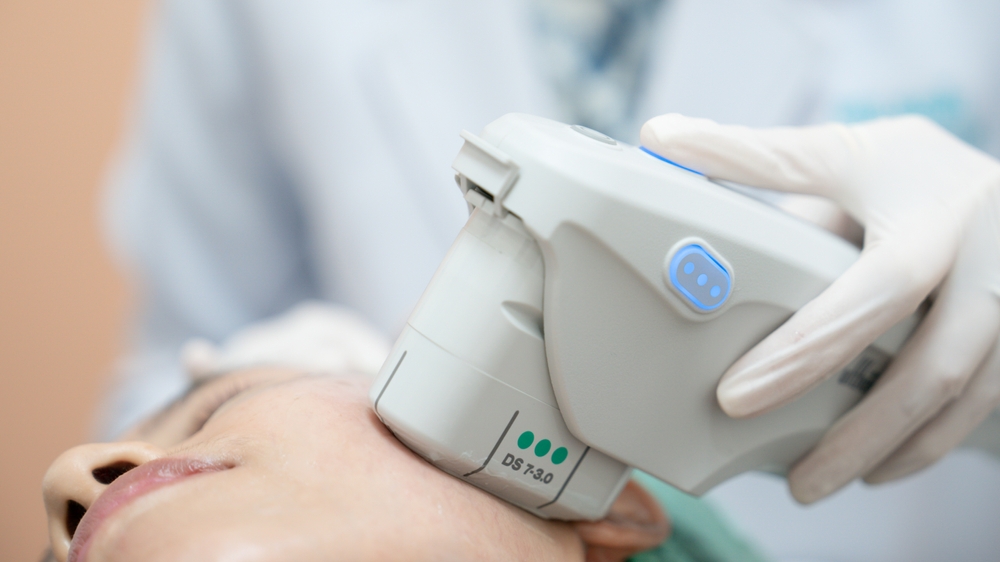 Close-up of Ultherapy treatment in progress, showcasing the device using focused ultrasound energy on a patient's face for deep skin rejuvenation.