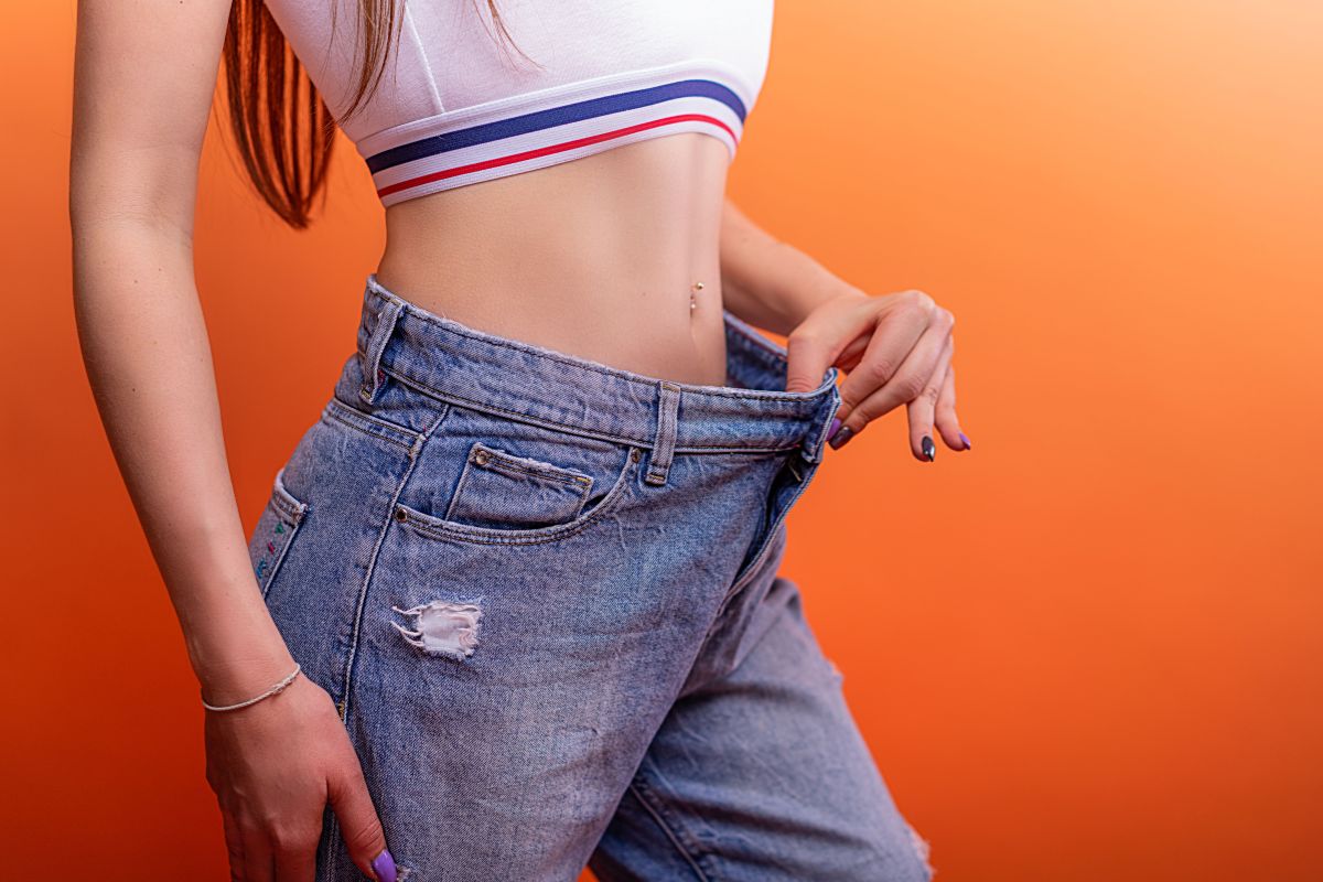 Woman measuring her waist after a CoolSculpting treatment, emphasizing the importance of post-treatment care for optimal results.